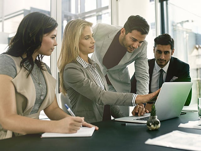 Group of workers looking at an open laptop