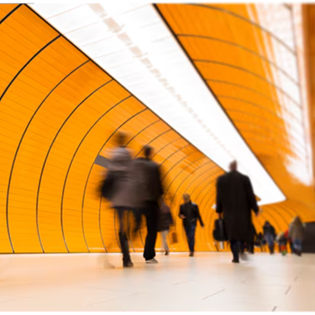 People walking through an orange tunnel