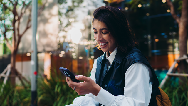 woman smiling while talking to a phone