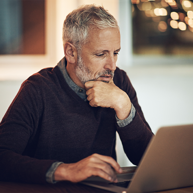 Mature man working late on a laptop