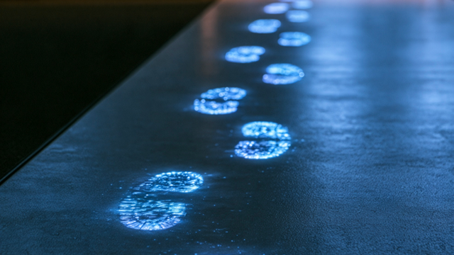 Illuminated blue footprints glowing in a dark office