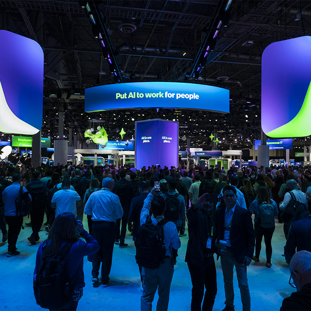A crowd of people on the Knowledge expo floor under a banner that reads “Put AI to work for people”
