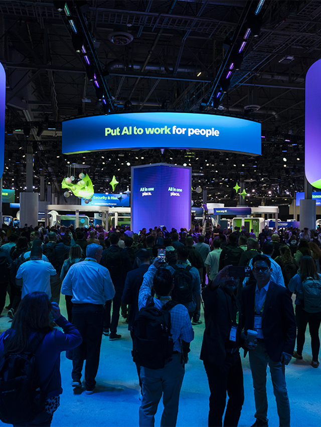 A crowd of people on the Knowledge expo floor under a banner that reads “Put AI to work for people”