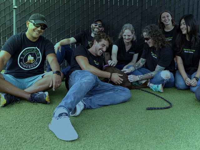 A group of people together with a puppy