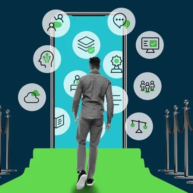 Man walking on a green carpet lined with stanchions toward a light blue human-size phone dotted with icons