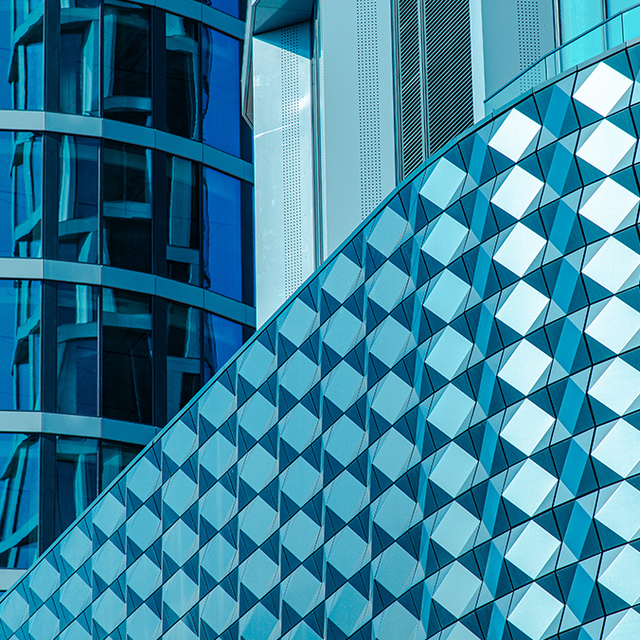 Close-up of a modern building facade made of glass, metal, and steel of various shapes