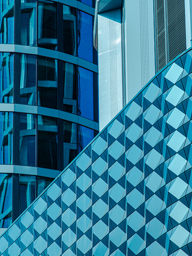 Close-up of a modern building facade made of glass, metal, and steel of various shapes