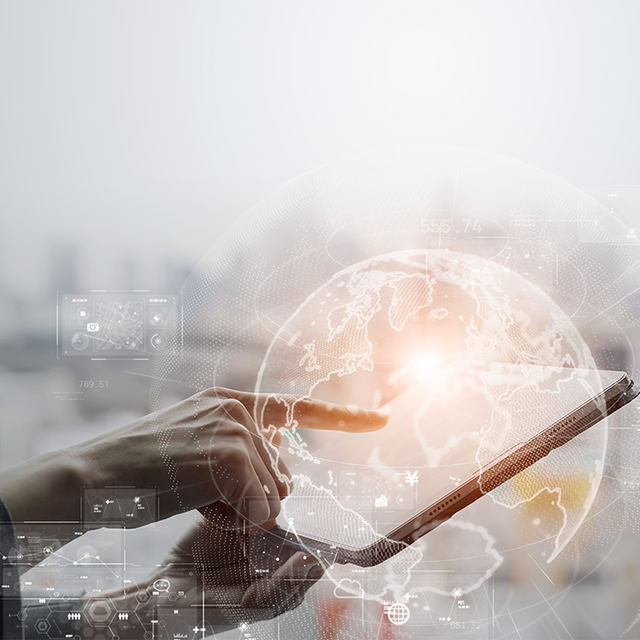 Finger pointing at a tablet with an overlay of a globe