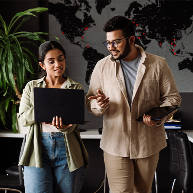 Two employees working together in an office to address business problems