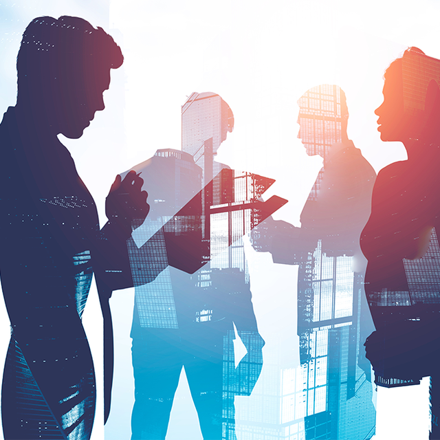Silhouettes of business people working against a city background