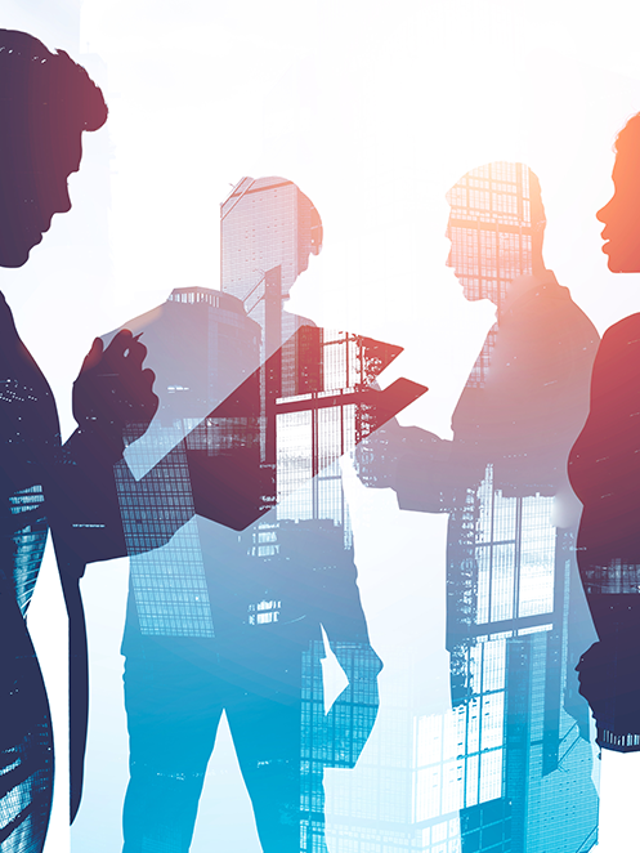 Silhouettes of business people working against a city background