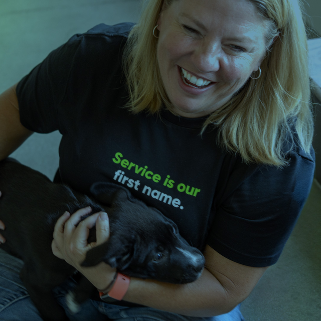 Female sitting on floor holding puppy