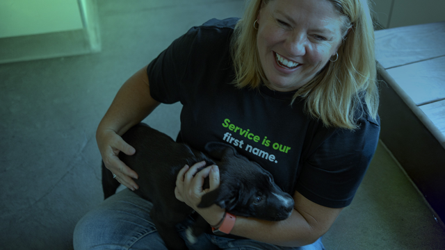 Female sitting on floor holding puppy
