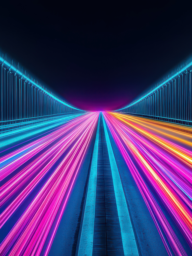 Neon light trails in blue, pink, and orange along a futuristic bridge