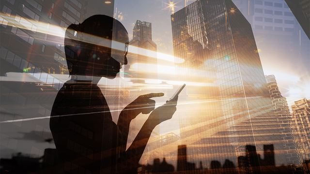 Woman using a smartphone with glowing streaks of light and motion blur in a modern city