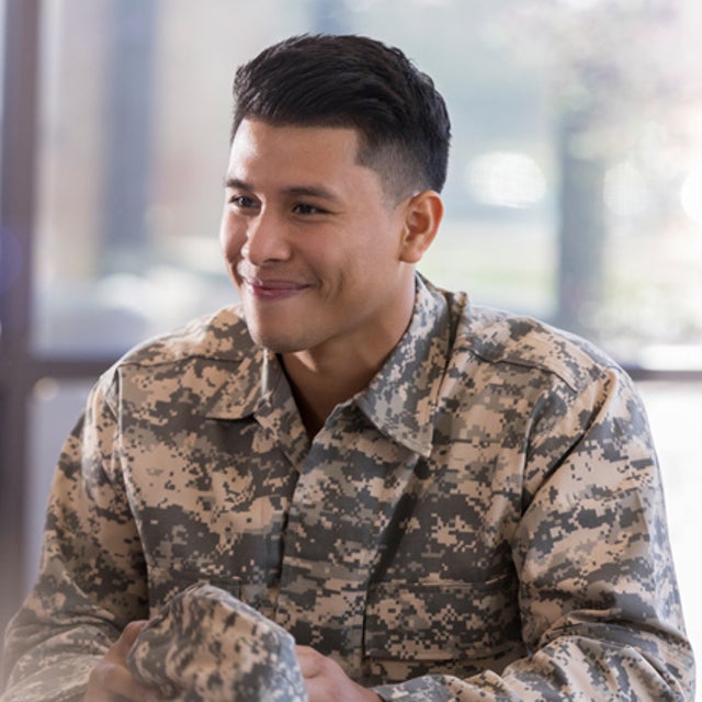 Man in camo uniform chatting with civilian woman in an office