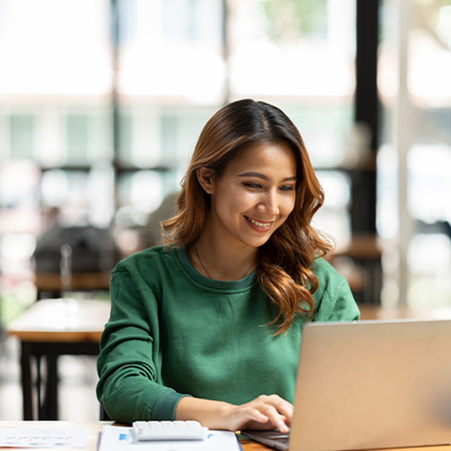 Woman sitting at desk in front of laptop
