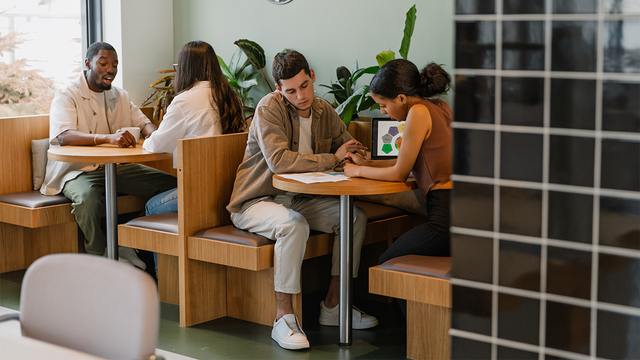 Four engaged workers at booths in an office setting