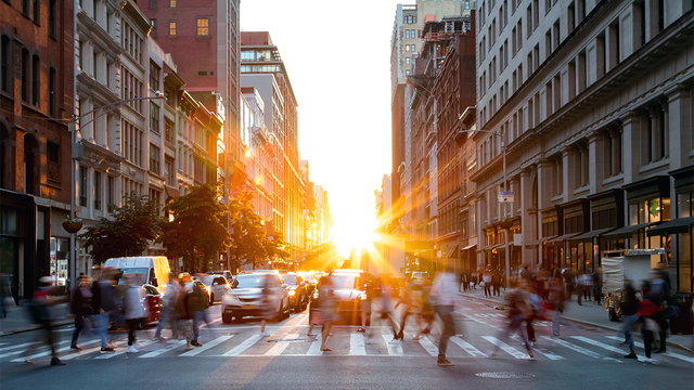 Busy people walking through the intersection of 5th Avenue and 23rd Street in Manhattan, New York City