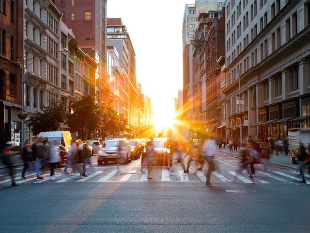 Busy people walking through the intersection of 5th Avenue and 23rd Street in Manhattan, New York City