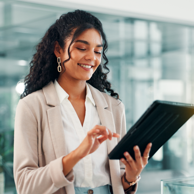 Happy woman working on a tablet in a bright office