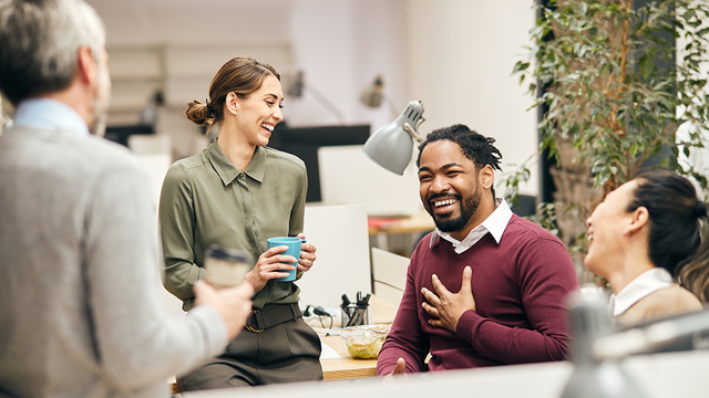 A group of happy workers around cubicles in an office