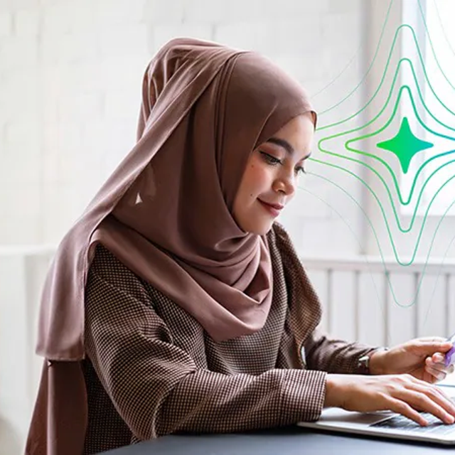 Woman wearing a hijab working on a computer in a bright office