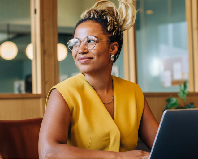 Female sitting in front of a laptop looking to her side