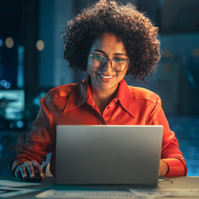Woman working on a laptop in an office at night