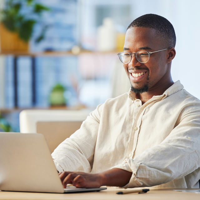 Confident man typing on a laptop in a bright office