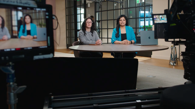 ServiceNow employees Caroline Agin and Deepika Dahiya at a desk for a video shoot