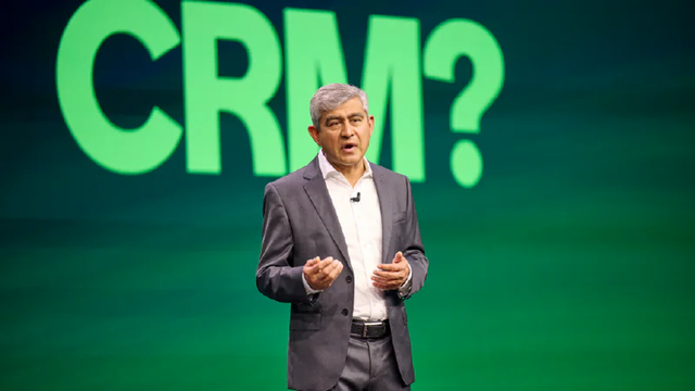 ServiceNow President, CPO, and COO Amit Zavery in front of a display that says "CRM?"