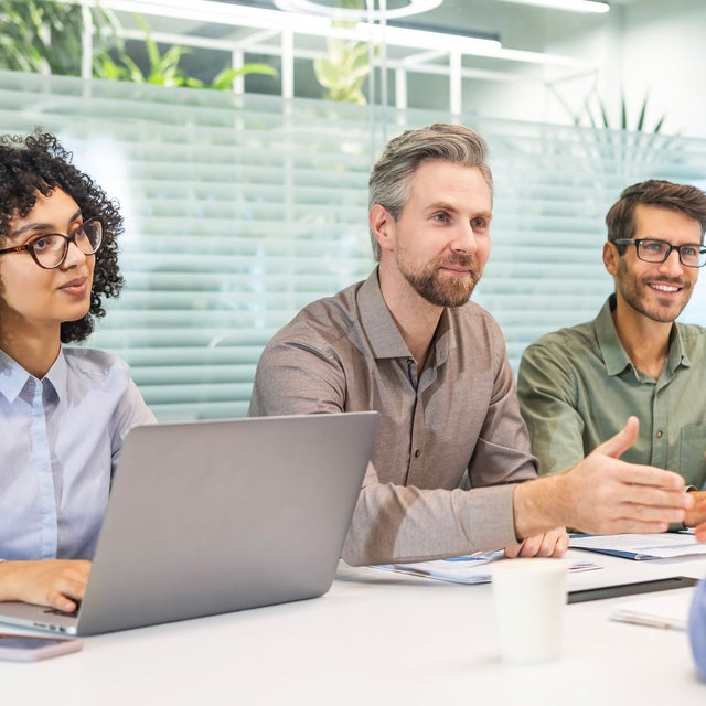 HR shared services: workers engaged in conversation at a conference table
