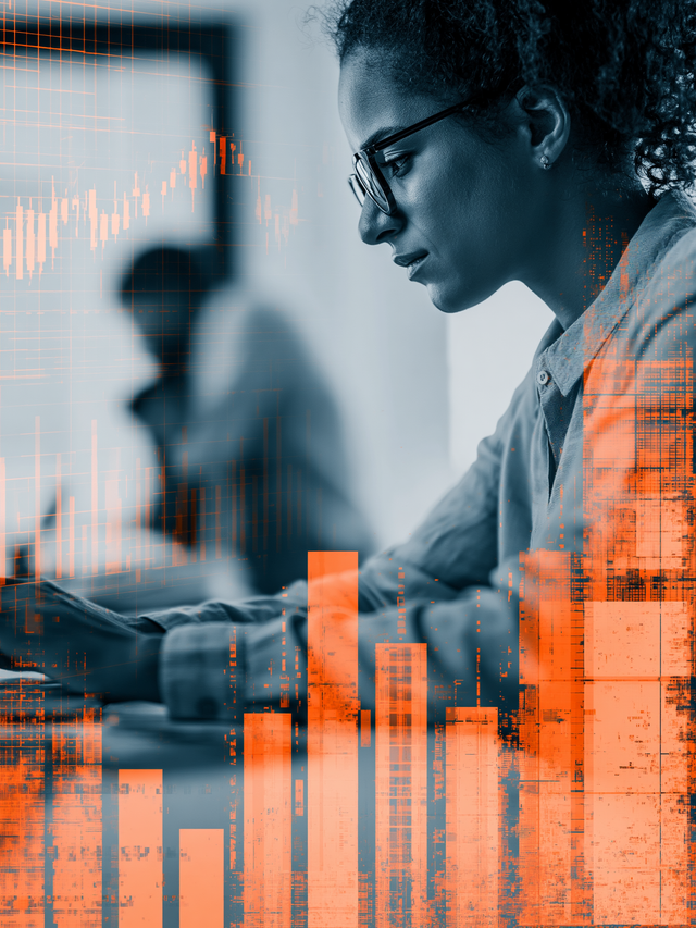 Woman in black and white working on a computer behind an overlay of orange graphs