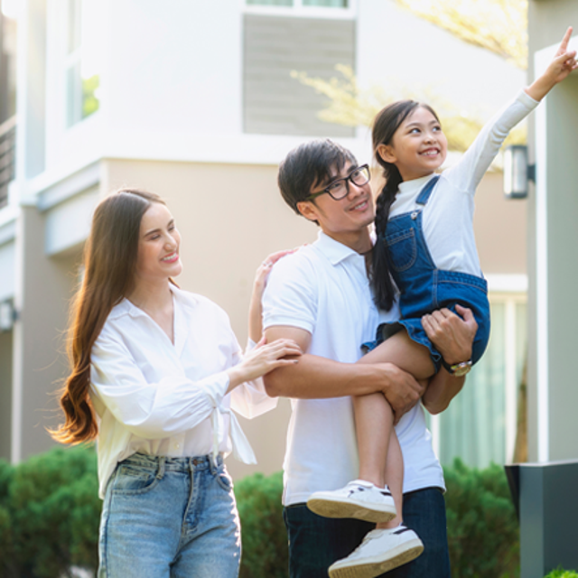 Young family in front of their new home