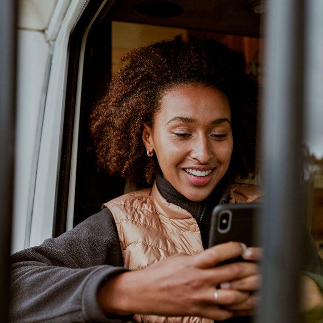 Woman in a vehicle looking at a phone