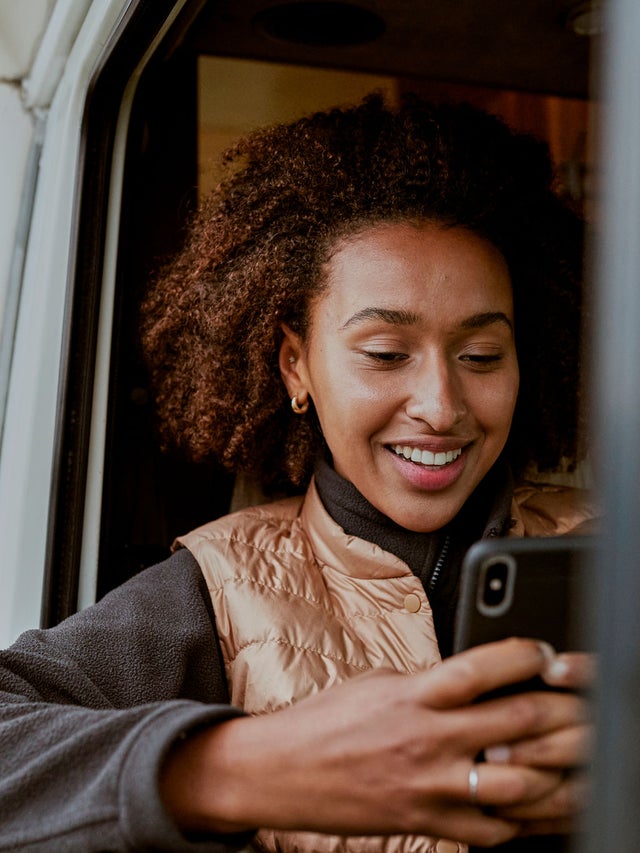 Woman in a vehicle looking at a phone
