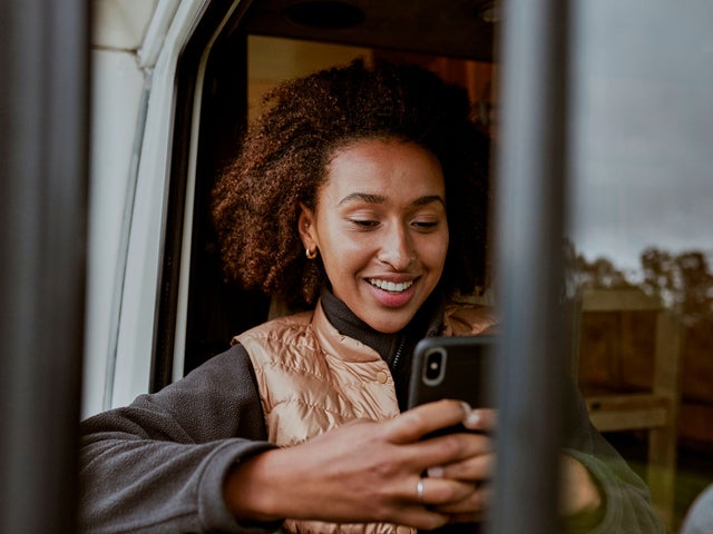 Woman in a vehicle looking at a phone