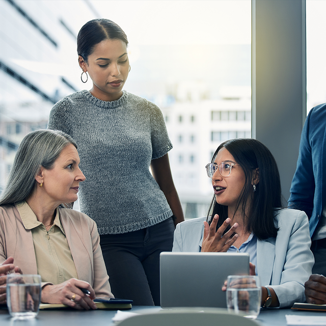 Group of workers collaborating around a conference table in a high-rise office