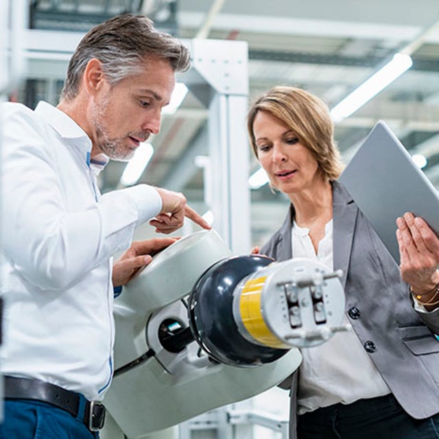 Intelligent automation: man and woman examining robotic machinery