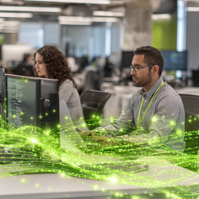 Workers sitting in an office at computers with abstract green waves going across the image