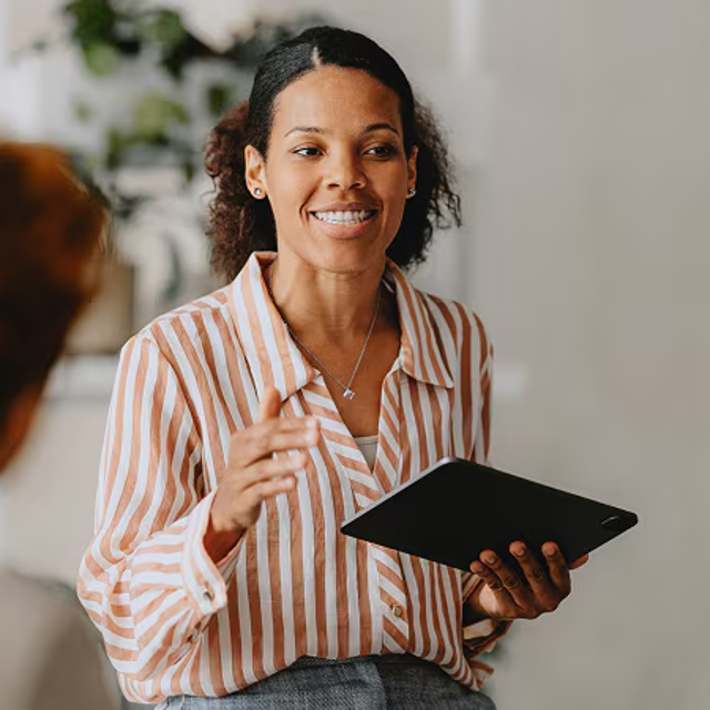 Woman holding a tablet collaborating with two co-workers