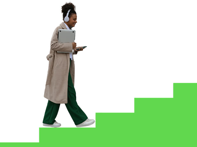 Female with headphones walking up stairs carrying laptop and phone