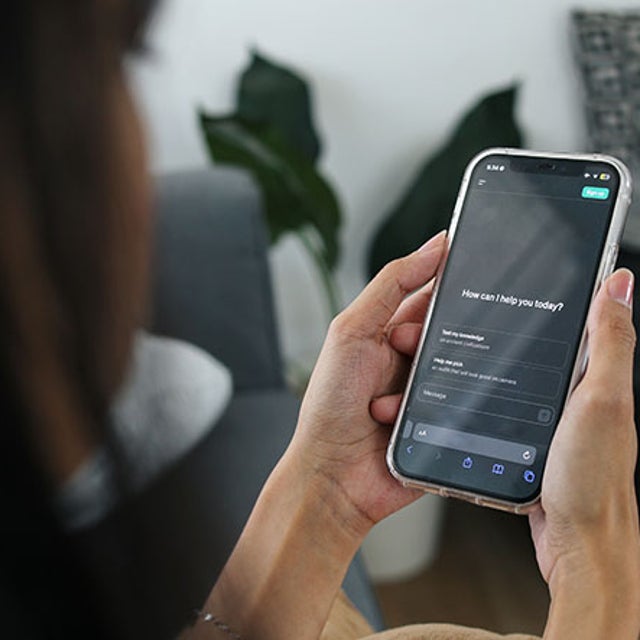 Woman looking at AI prompt on a smartphone in her hands