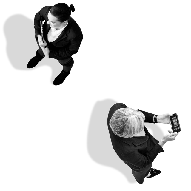 Two women standing apart. One holding clipboard, the other woman looking at phone.