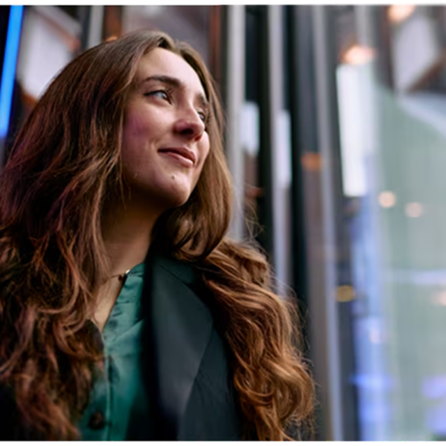 Woman with long hair looking out a window
