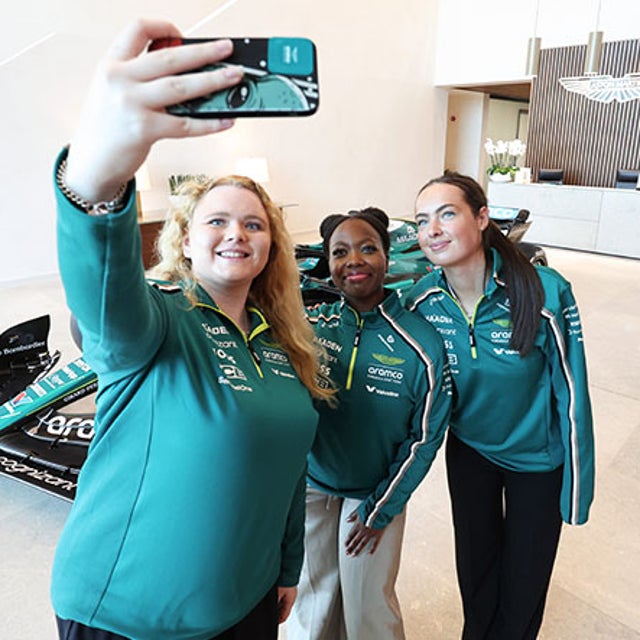 3 young women in tech taking a selfie at the Aston Martin Aramco racing team campus