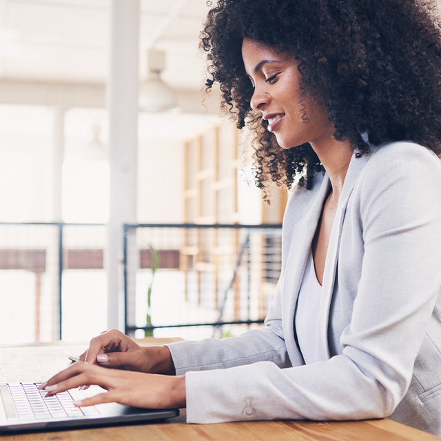 Woman working on a laptop in a bright office