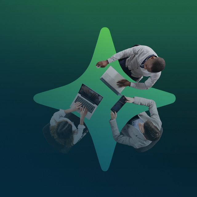 Overhead shot of three people at a four-pronged-AI-star table working on laptops