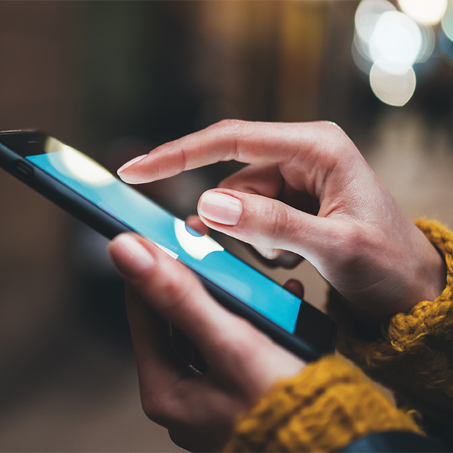 Close-up of two hands holding and using a phone